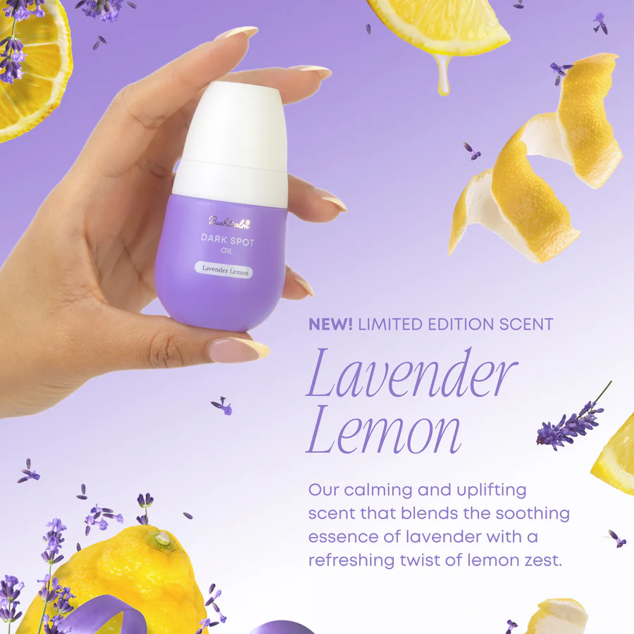 Hand holding Bushbalm Lavender Lemon Oil dark spot serum with floating lavender and lemon peel on purple background